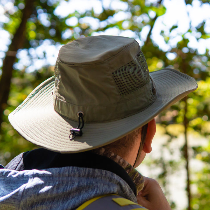 Person wearing a wide-brimmed hat in a forest setting