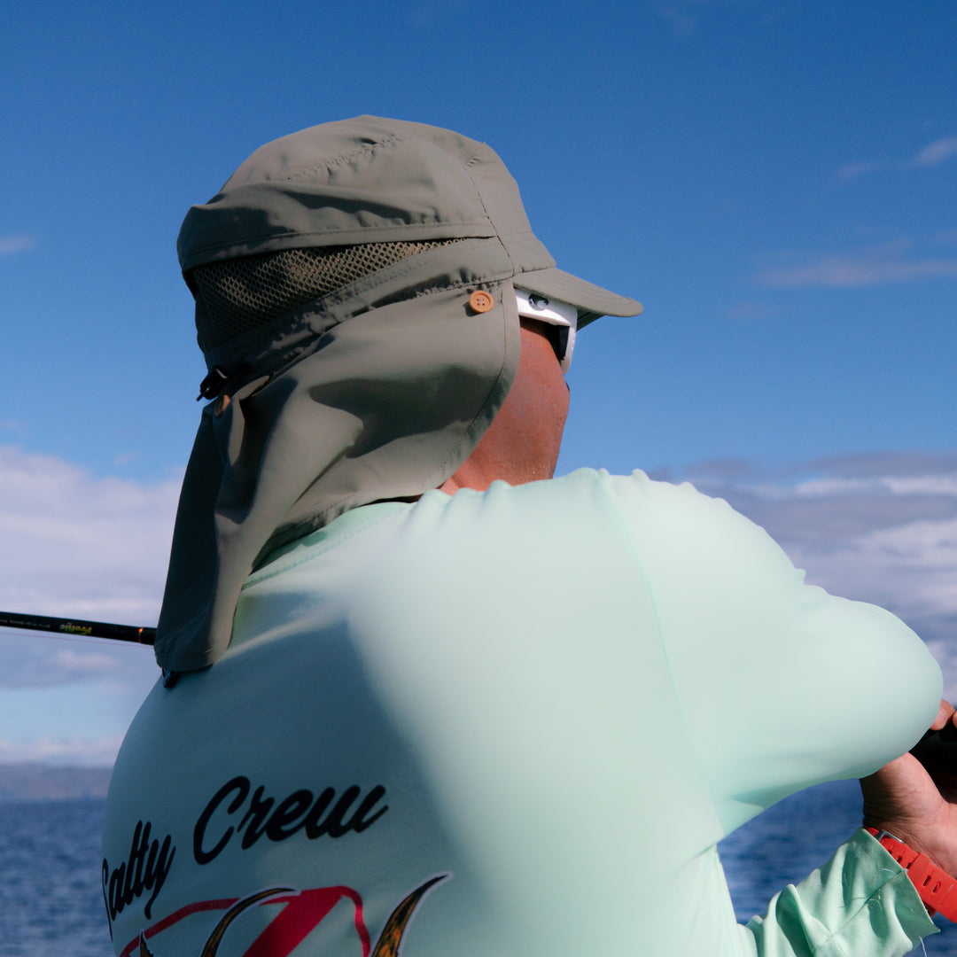 Person fishing on a boat with a blue sky and water background